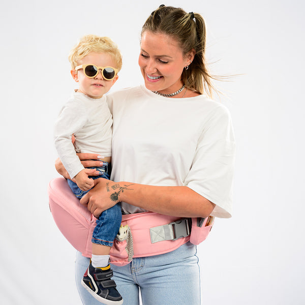 une femme avec un porte bebe rose