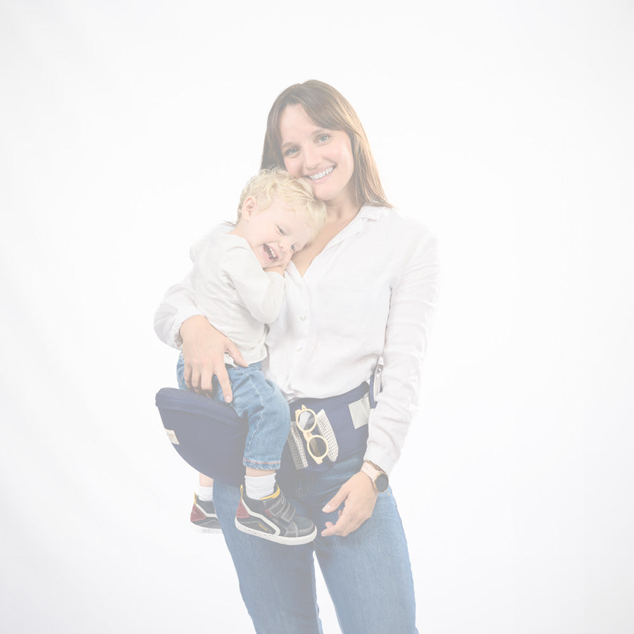 une femme portant son bébé avec un porte bébé bleu en studio photo