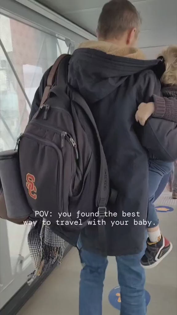 un homme transportant son bébé à l'aéroport 